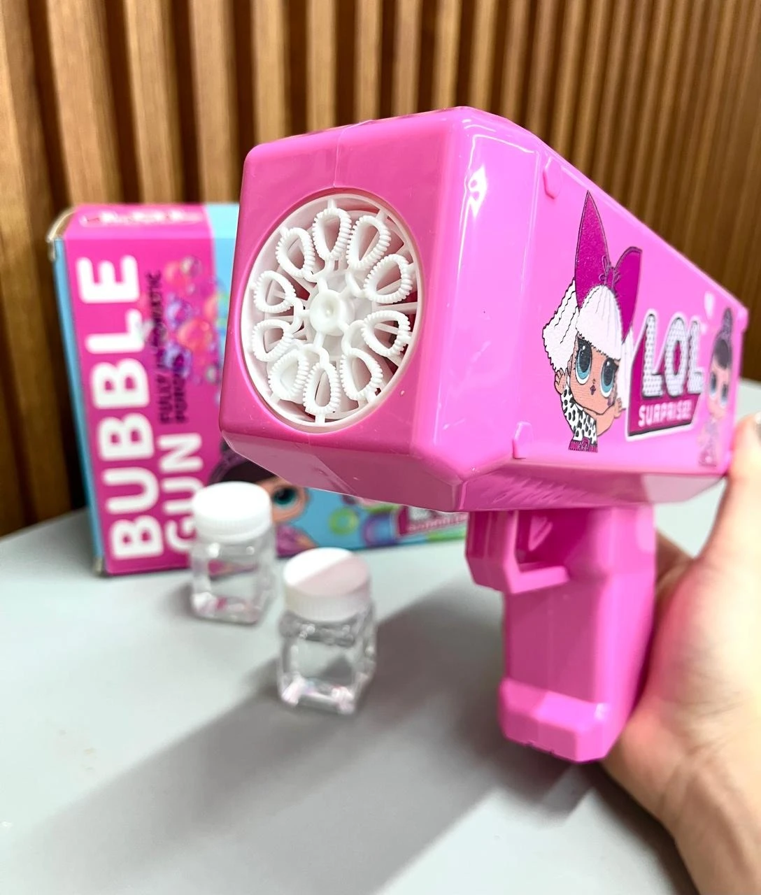 Pistola de burbujas automática rosa con diseño de Lol Surprise, incluye solución líquida y caja original. Ideal para fiestas infantiles.
