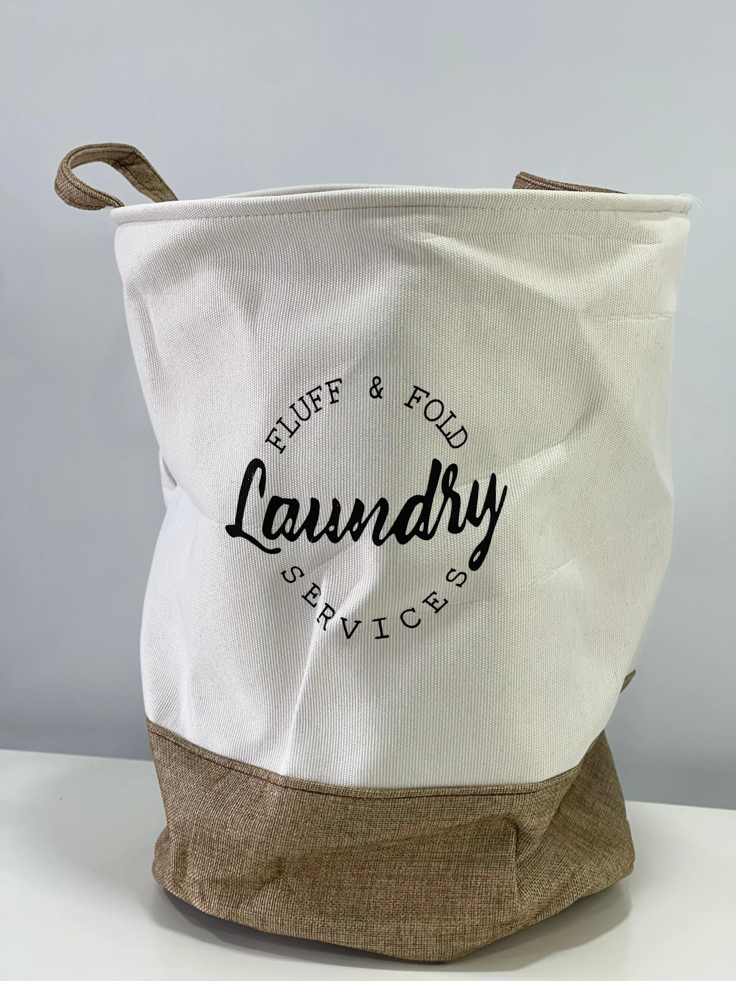 Cesto de tela gris y blanco para ropa sucia, con diseño minimalista y texto "Laundry Services".