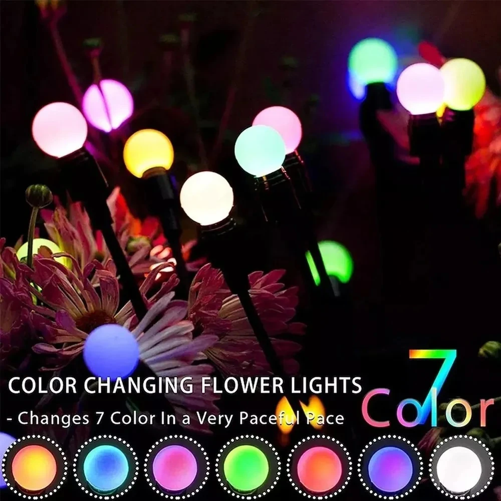 Luces solares de jardín con siete esferas LED multicolor, montadas en varillas flexibles, entre flores artificiales; cambian de color y se mueven con el viento.
