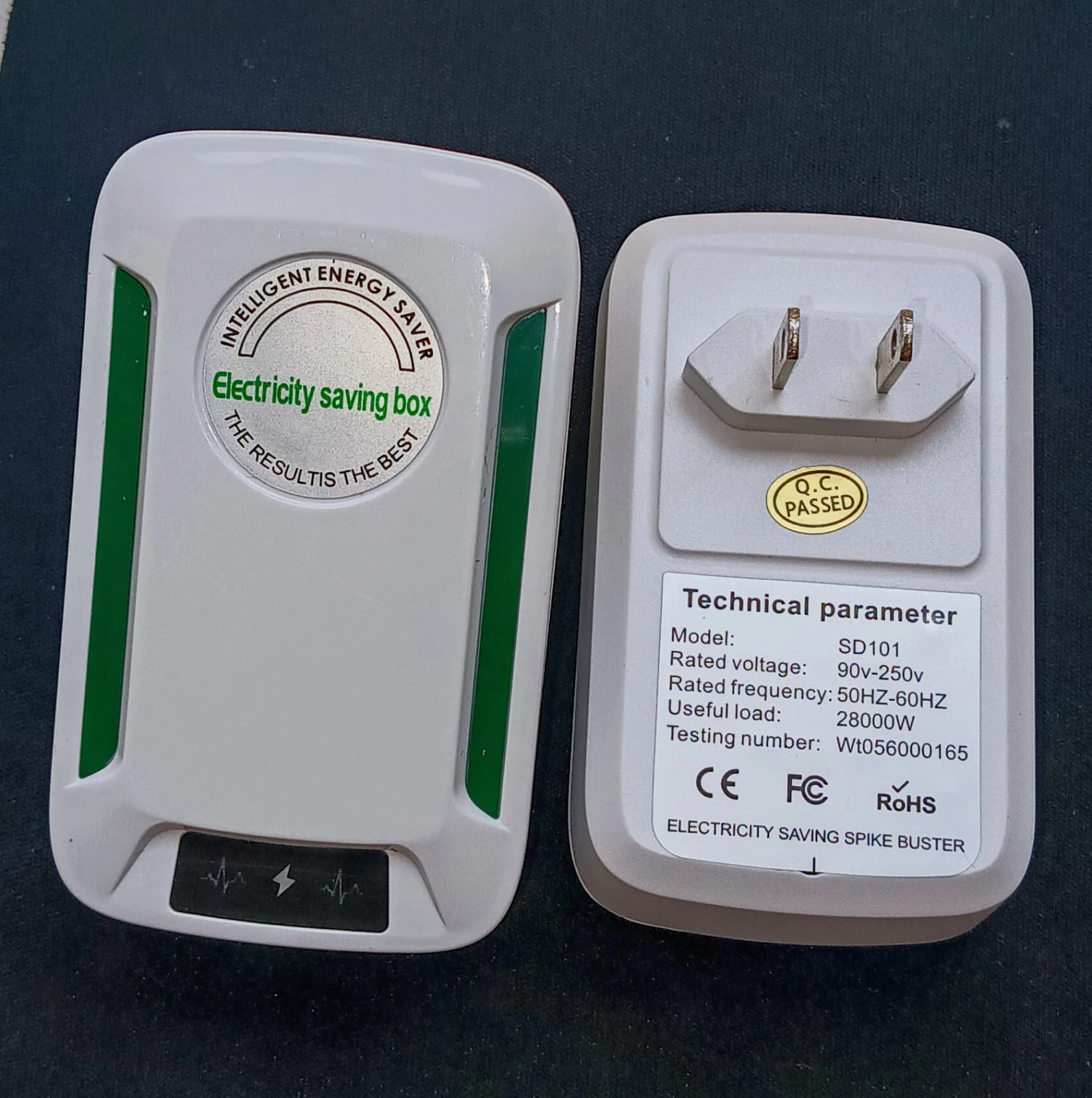 Regulador de voltaje inteligente blanco con etiqueta de ahorro energético y ficha técnica visible, mostrando dos unidades: frontal y trasera con enchufe.