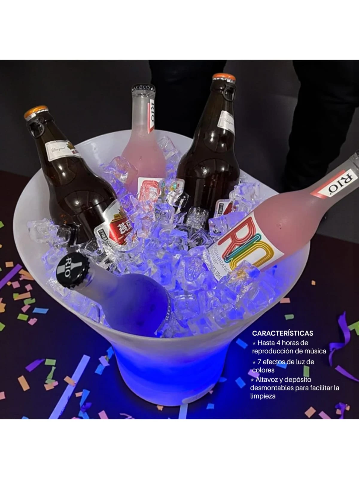 Hielera cubeta blanca con luz LED azul y altavoz Bluetooth, conteniendo cuatro botellas de bebidas sobre hielo y confeti en el fondo.
