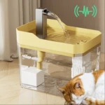 Dispensador automático de agua para mascotas en color amarillo, con filtro interno visible y grifo metálico vertiendo agua. Gato durmiendo al lado.