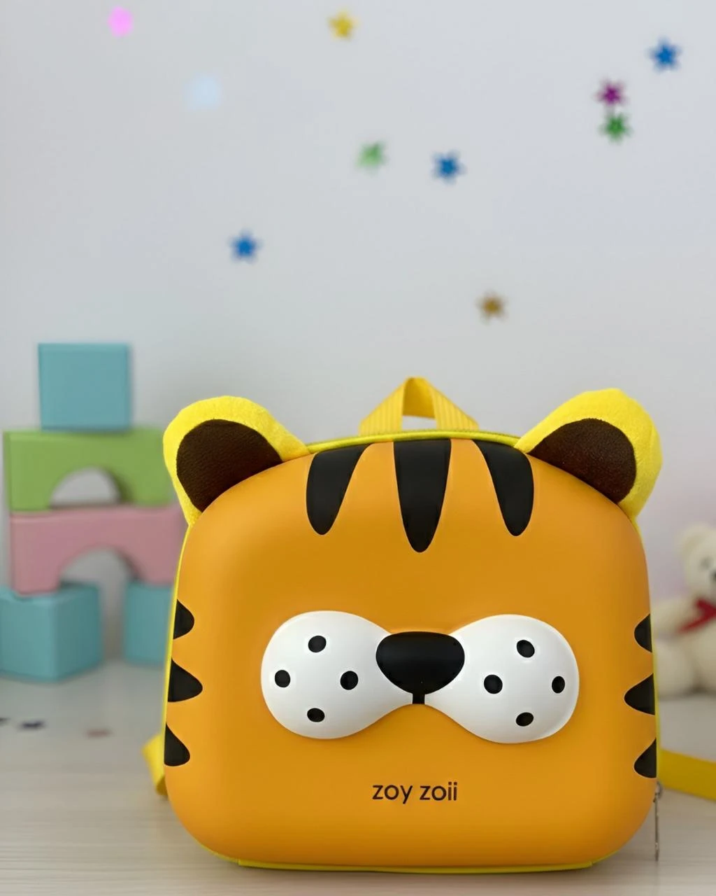 Mochila infantil amarilla con diseño de tigre, orejas tridimensionales y detalles en negro y blanco. Marca Zoyzoii visible en la parte frontal.