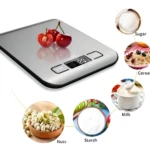 Balanza digital de cocina en acero inoxidable con pantalla LED, mostrando cerezas y círculos con azúcar, cereal, nueces, almidón y leche.