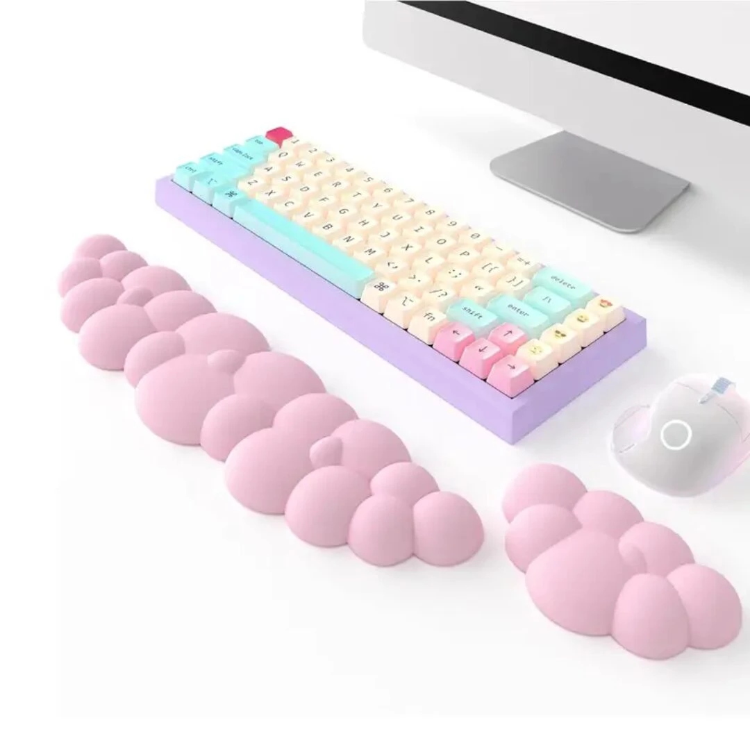 Reposamuñecas ergonómicos de espuma viscoelástica rosa con diseño de burbujas, junto a teclado pastel y mouse blanco.
