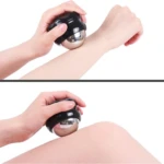 Masajeador roller terapéutico con bola metálica plateada y mango negro, usado en brazo y pierna para aliviar tensión muscular.