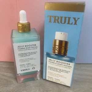 Serum Jelly Booster Truly, loción corporal pigmentante 90ml en frasco de vidrio con gotero dorado, caja azul.