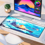 Mousepad gigante con diseño de buque de guerra disparando en mar azul brillante, colocado sobre escritorio junto a monitor y teclado blanco.