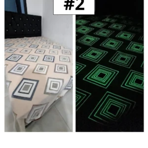 Cobija con estampado geométrico en tonos neutros, que brilla en verde bajo luz tenue, ideal para ambientar el dormitorio sin necesidad de batería.