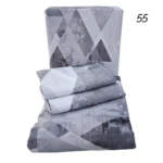 Set de tres sábanas microfibra con estampado geométrico en tonos grises y blancos, mostrando funda, bajera y dos almohadas dobladas.