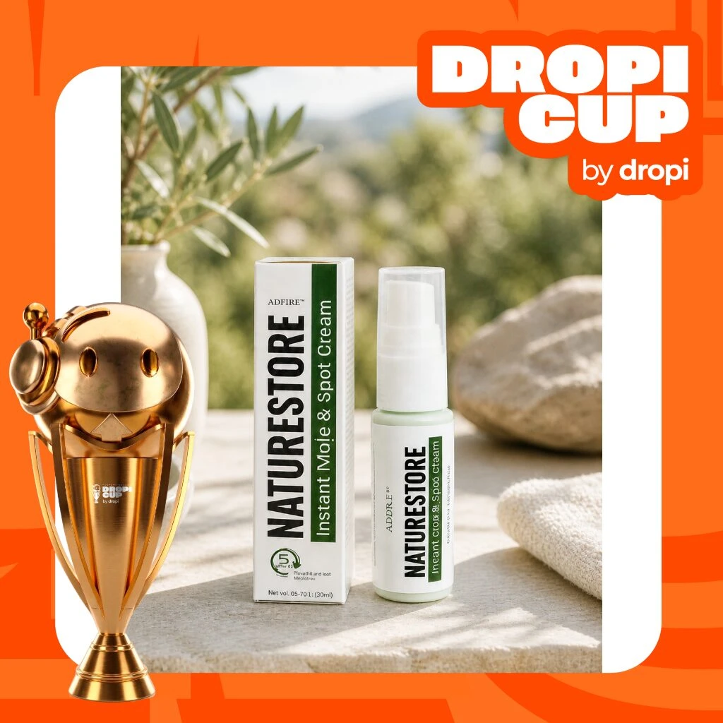 Trophy dorado junto a crema Naturestore Instant Mole & Spot Cream en presentación de 12 ml, con envase blanco y verde, sobre superficie clara al aire libre.