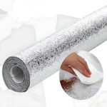 Roll de vinilo adhesivo plateado con textura ondulada para protección de paredes en cocina, resistente al calor y fácil de limpiar.