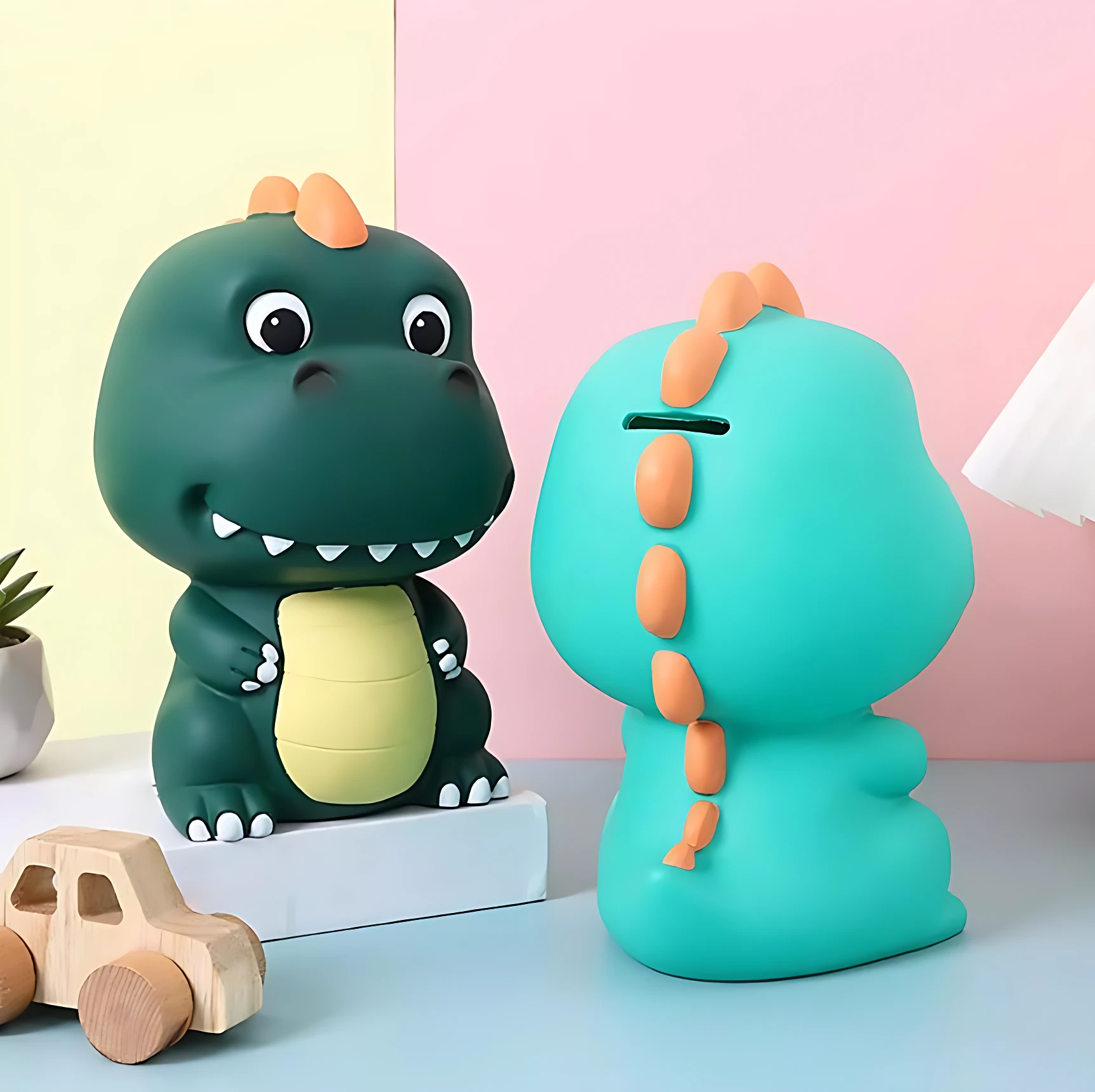 Alcancía de dinosaurio verde y turquesa, con detalles naranjas, ideal para niños.