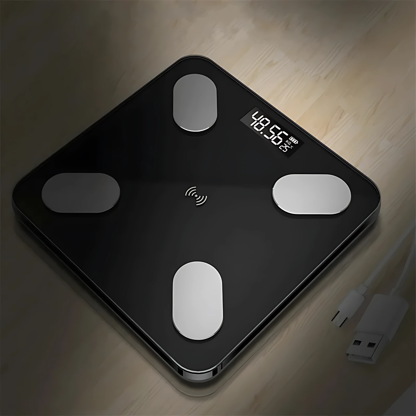 Báscula de grasa corporal negra con pantalla digital mostrando 48.56 kg, cuatro sensores metálicos y cable USB incluido, vista cenital sobre superficie de madera.