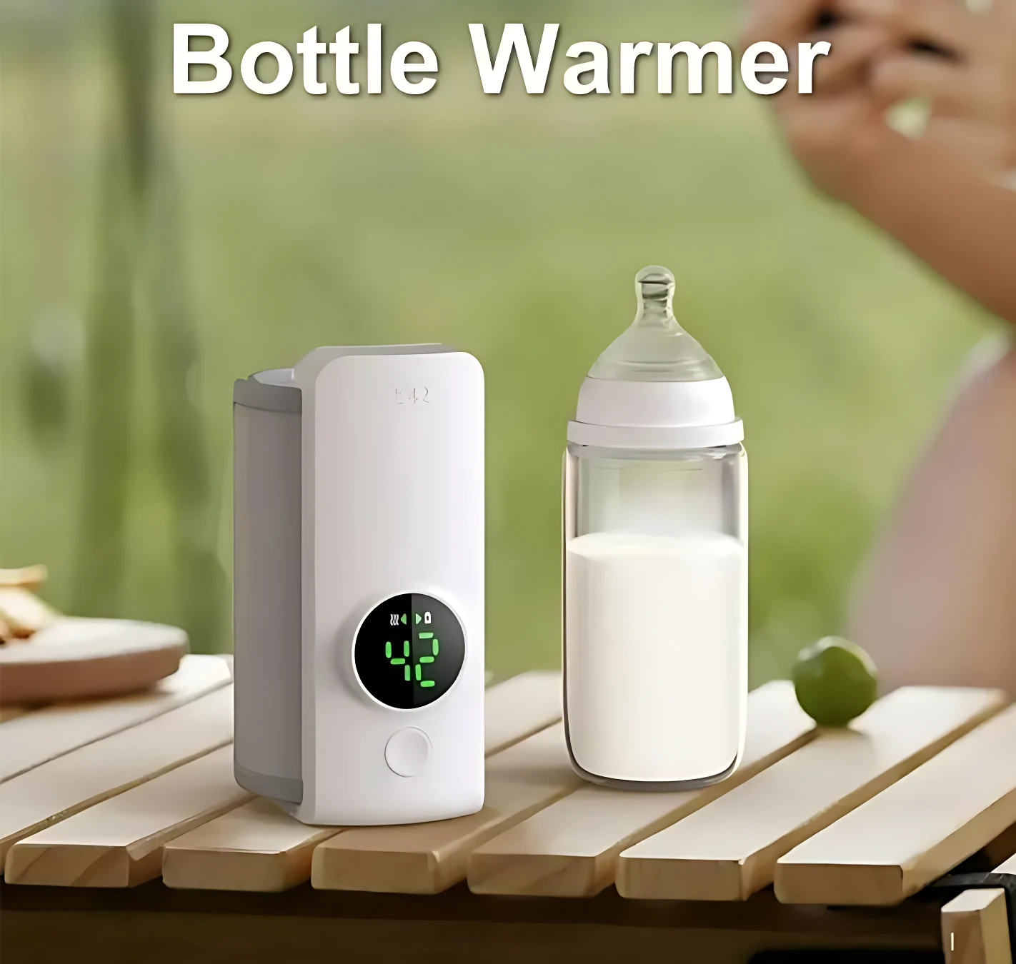 Calentador de tetero portátil inalámbrico blanco con pantalla digital mostrando 42°C, junto a un biberón de vidrio con leche, sobre mesa de madera al aire libre.