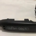 Candado de manillar negro con mecanismo de llave, diseñado para proteger el manubrio de motos y bicicletas.
