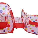 Carpa de juego infantil con túnel y canasta de baloncesto, diseño con lunares multicolores sobre fondo blanco y detalles en rojo.