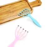 Set de 4 cepillos masajeadores manuales, uno azul y uno rosa, sobre bandeja de madera.