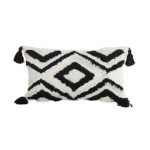Cojín rectangular blanco con diseño geométrico negro y flecos, estilo moderno.