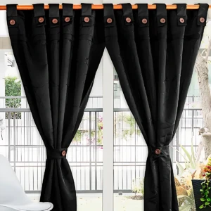 Cortina negra de tejido Jacquard con cordón y botones metálicos, colgada en ventana con marco blanco y vista exterior.