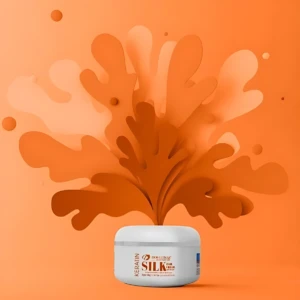 Crema para cabello con gusano de seda y queratina, en envase blanco, con fondo naranja y diseño abstracto.