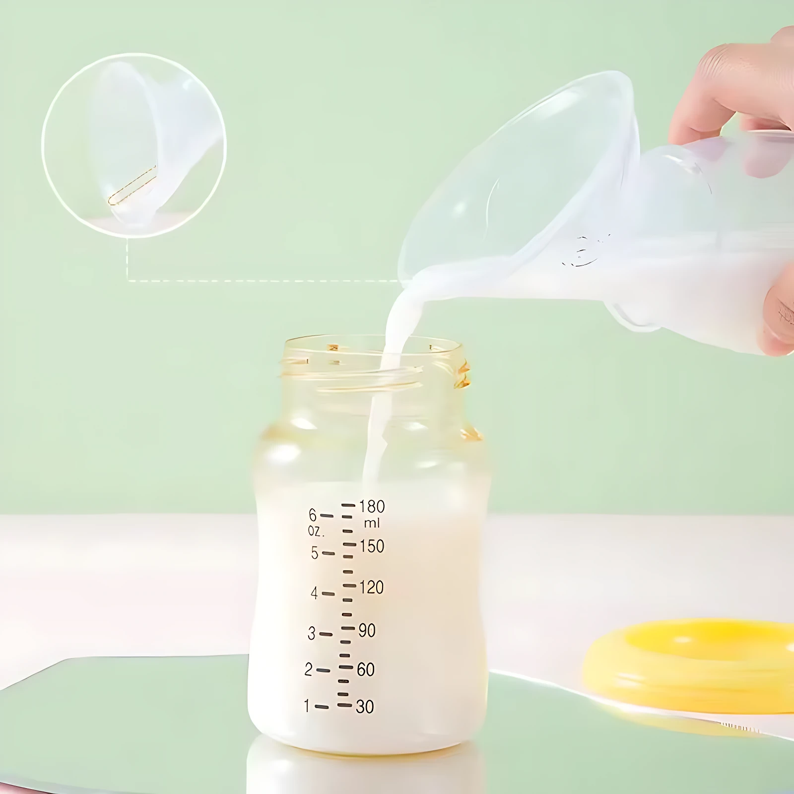 Extractor de leche manual en silicona transparente vierta leche en biberón con medidas, tapa amarilla visible al lado.