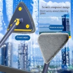 Fregona triangular con mango telescópico y exprimidor automático, mostrando cara frontal de microfibra gris y parte trasera con sistema de exprimido amarillo, en uso para limpieza de cristales con espuma.