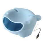 Fuente de agua automática para mascotas en color azul claro, con forma de cabeza de animal y cable USB visible.