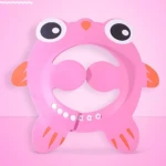 Gorro de baño infantil rosa con diseño de ranita, ojos grandes y boca abierta, incluye detalles en naranja y perlas blancas.
