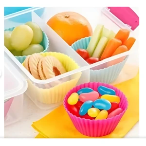 Lonchera infantil con moldes de silicona en colores rosa, azul y amarillo, organizando frutas, verduras, galletas y dulces en compartimentos separados.