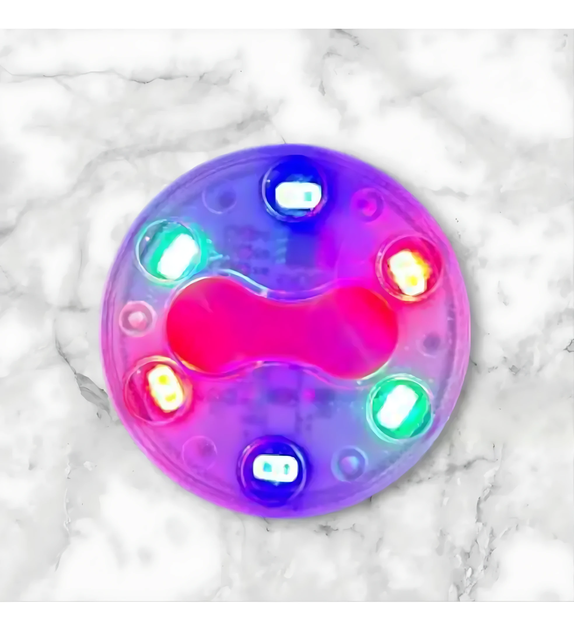 Luces traseras para bicicleta recargables USB, modelo circular con seis LEDs multicolores en tonos neón sobre base translúcida, vista superior sobre superficie de mármol blanco.
