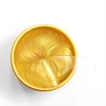 Parches para ojeras con oro de BIOAQUA en contenedor dorado, expuestos y listos para usar.
