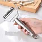 Pelador rallador multifuncional de acero inoxidable plateado en mano, ideal para verduras.
