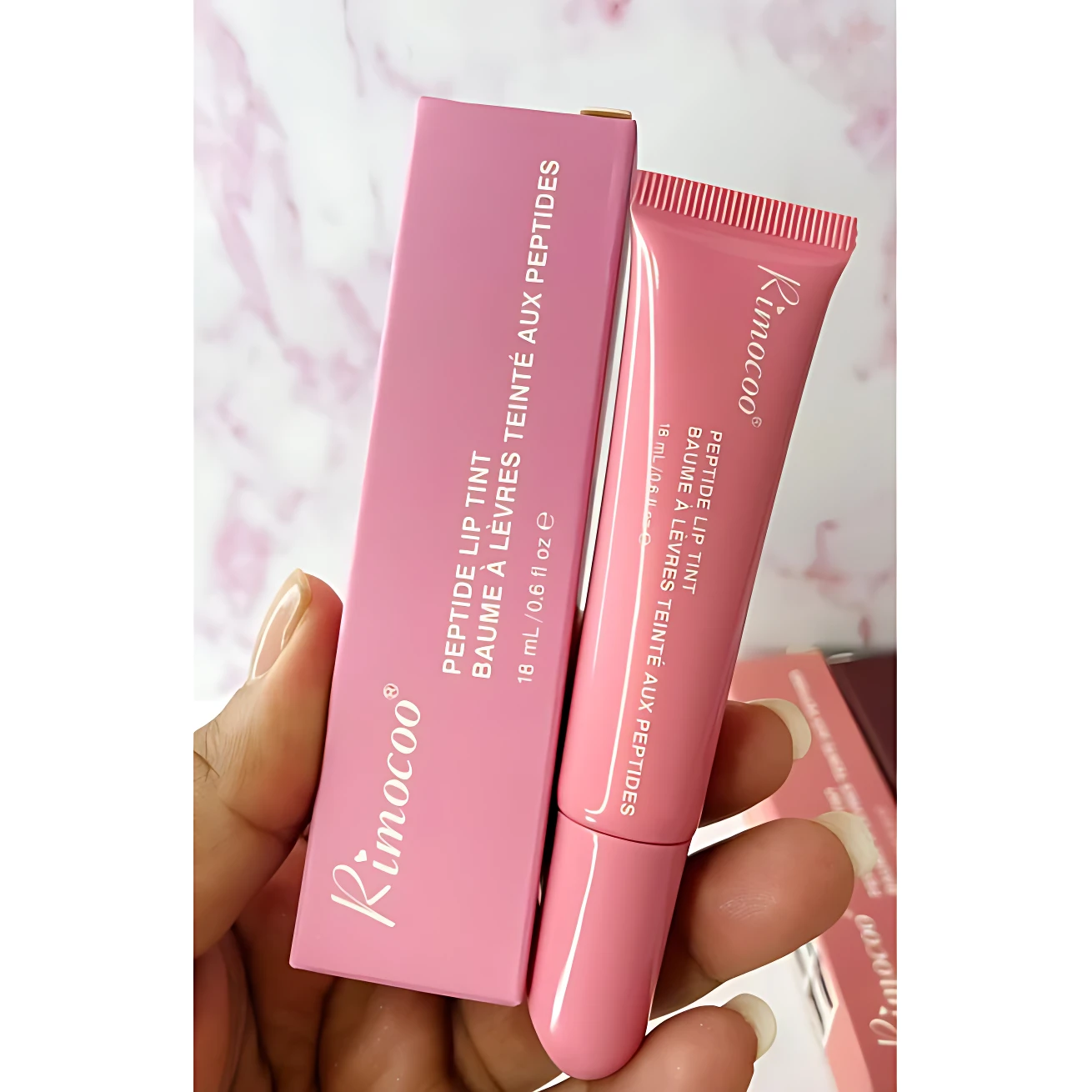 Bálsamo labial Rimocoo rosa con péptidos, caja y tubo de 18 ml.