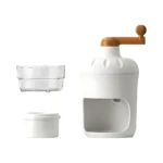 Picador de hielo manual blanco con manivela marrón. Vista de conjunto mostrando el cuerpo principal, un recipiente transparente y un contenedor blanco. Diseño compacto.