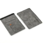 Protector pasaporte en cuero sintético gris, mostrando interior con ranuras para tarjetas y exterior con grabado de avión y texto.