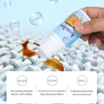 Quitagrasa portátil en tubo blanco con etiqueta azul, aplicándose sobre tela blanca con manchas de aceite, café y sudor. Incluye iconos que indican uso sin agua, ingredientes desinfectantes y formato compacto.