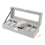 Relojero X6 gris claro con cristal transparente y llave incluida, mostrando seis compartimentos para relojes y un reposo central.