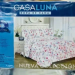 Juego de sábanas Casaluna 4 piezas con estampado floral rosa y azul. Muestra medidas: sábana 203x235 cm, forro 137x190+21 cm y fundas 50x76 cm. Se muestra la cama.