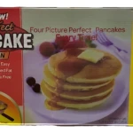Caja del sartén antiadherente Perfect Pancake, con de pancakes dorados y frutas, muestra cuatro recetas incluidas: arándanos, manzana canela, jengibre y chocolate.