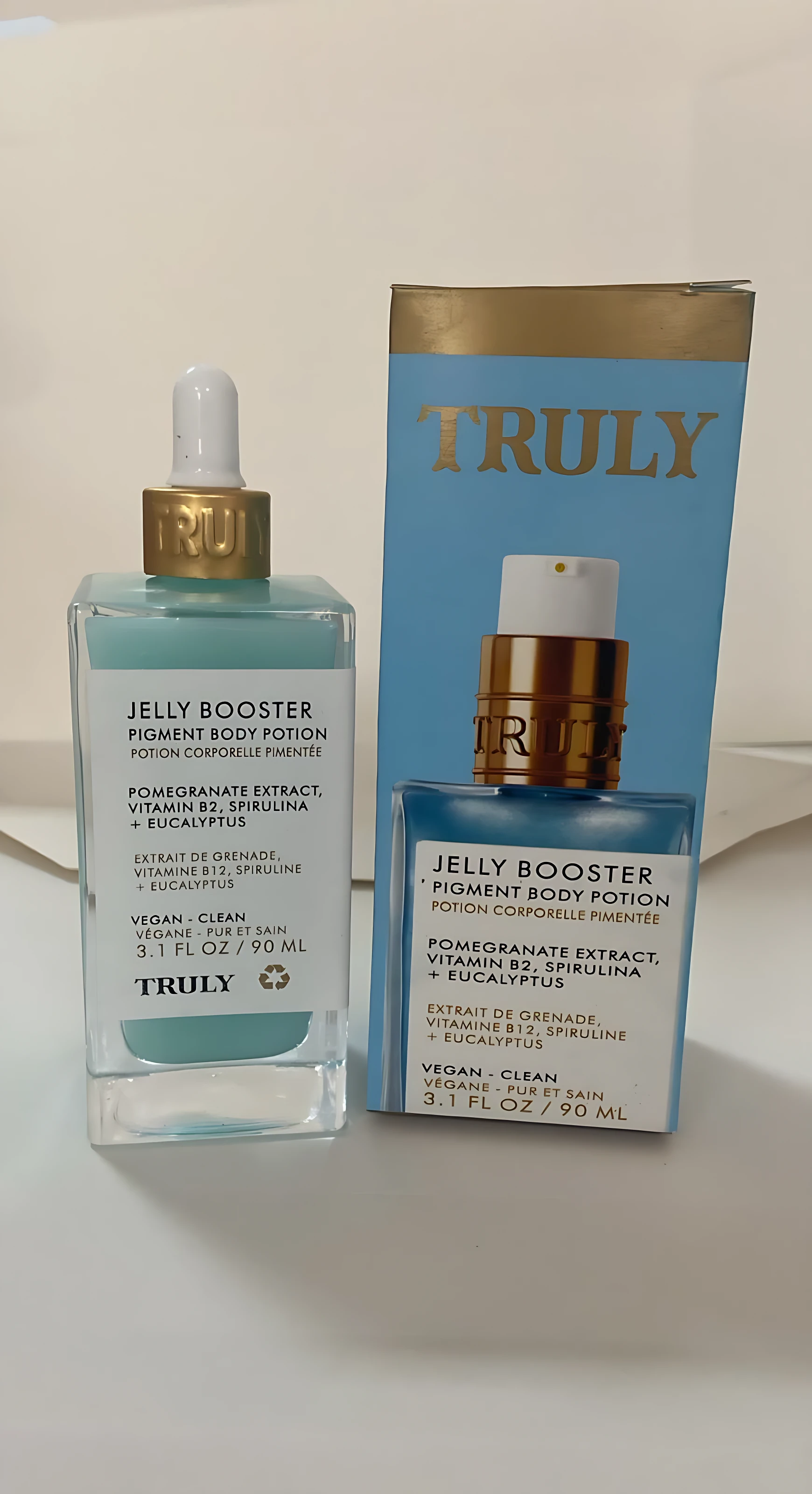 Serum Jelly Booster Truly 90ml, loción corporal pigmentante azul con gotero dorado, en caja azul.