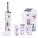 Set de seis accesorios de baño con diseño marino: escoba, portarrollos, dos cepillos, cubo y tapa, todos con estampado de estrellas de mar y corales en tonos pasteles.
