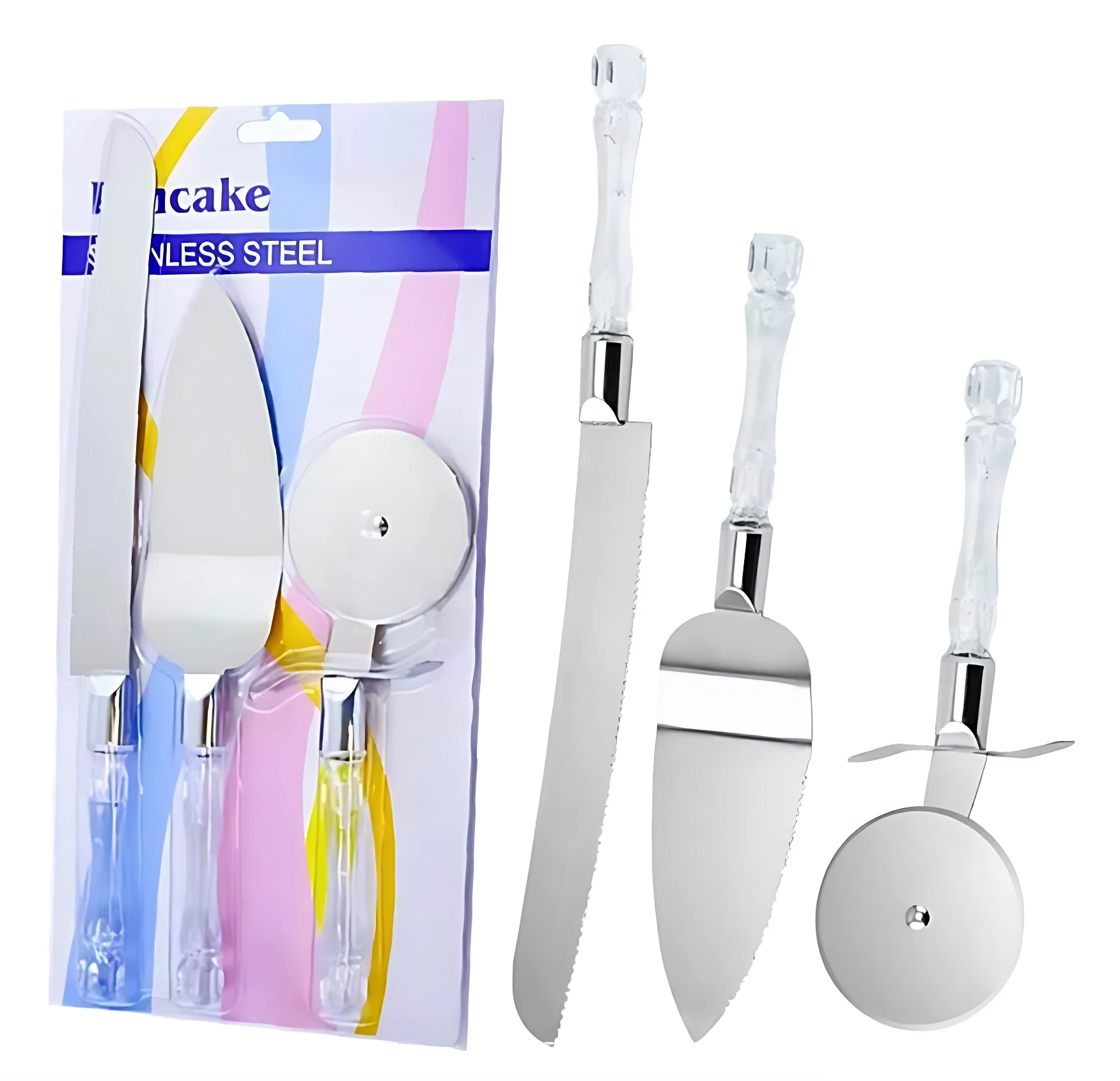 Set de tres utensilios de cocina en acero inoxidable con mangos acrílicos transparentes: cuchillo serrado, espátula y rodillo para pizza, mostrados en empaque y fuera de caja.