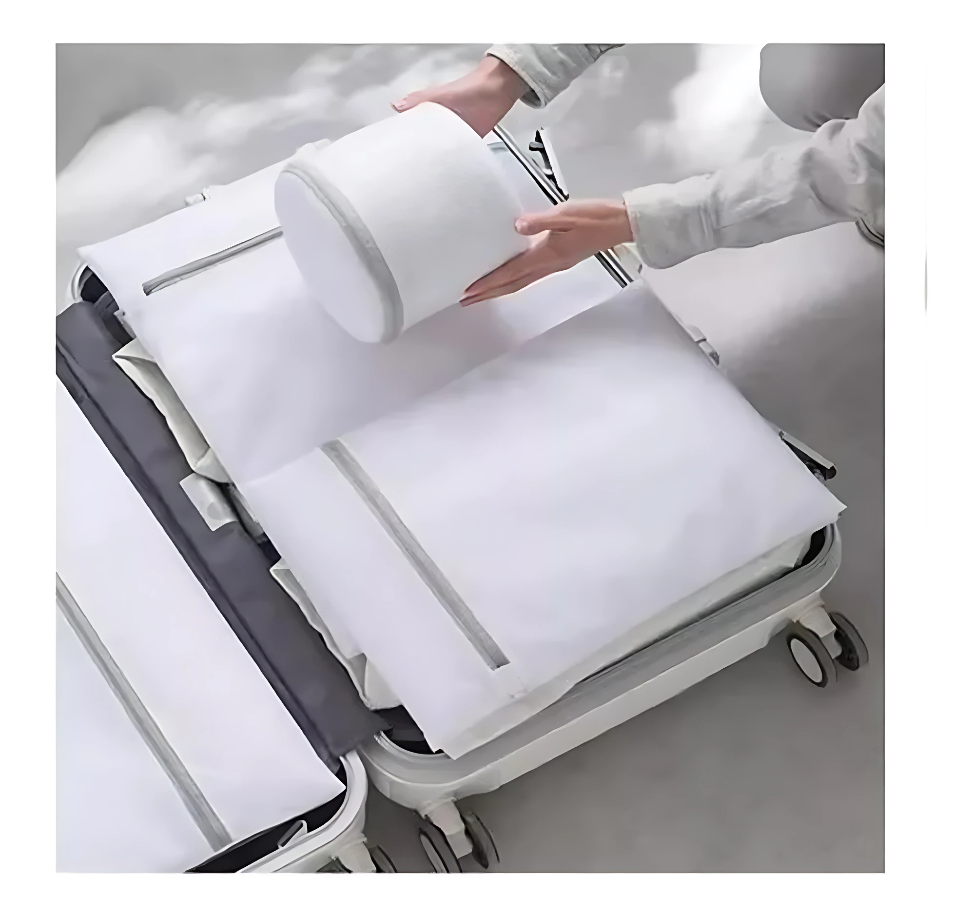Bolsas de malla blanca en forma de rodillo y plana organizadas dentro de una maleta abierta, con manos colocando el cilindro, para lavar y organizar ropa delicada.