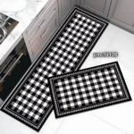 Tapetes absorbentes de diseño a cuadros negro y blanco con borde decorativo, presentados en dos tamaños para cocina o baño.