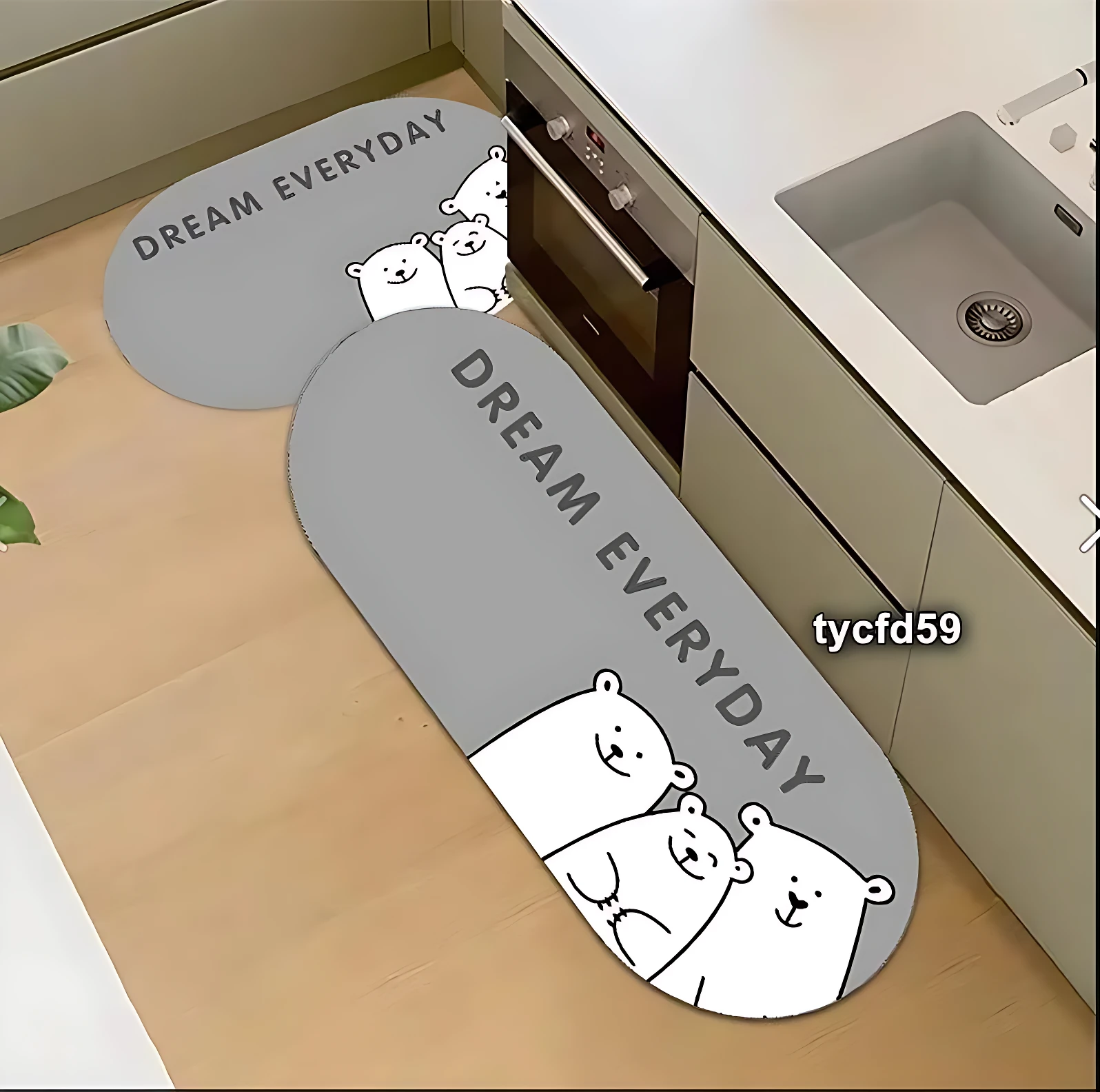 Tapetes absorbentes grises con diseño de ositos y frase Dream Everyday, uno largo y otro pequeño, colocados en cocina junto a fregadero y horno.