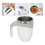 Taza mezcladora automática giratoria blanca con mango ergonómico, interior metálico y tapa con dos varillas de mezcla. Muestra en uso con líquido marrón.