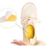 Tiras desodorantes para calzado, color amarillo, insertadas en zapatilla beige con cordones; ampliación muestra forma ergonómica y capa absorbente.
