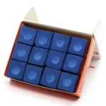 Caja abierta con seis cubos de tiza azul para billar, dispuestos en dos filas de tres, mostrando su superficie con huellas de dedos.