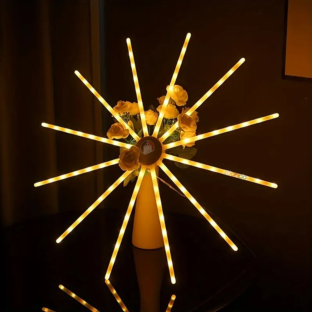 Lámpara LED estrella auditórica con 12 brazos giratorios, luces amarillas cálidas y centro decorativo con flores artificiales.